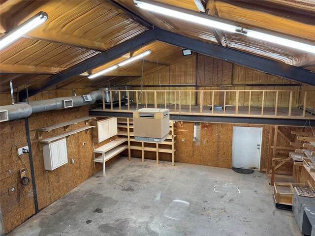 interior space with vaulted ceiling and concrete floors