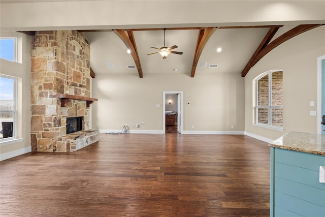 unfurnished living room with ceiling fan, dark wood-type flooring, a wealth of natural light, and a fireplace