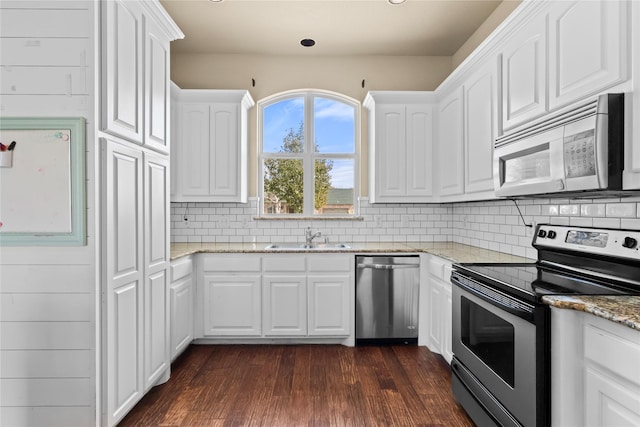 kitchen featuring dark wood-type flooring, sink, white cabinetry, stainless steel appliances, and light stone countertops