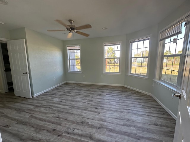 empty room with hardwood / wood-style floors and ceiling fan