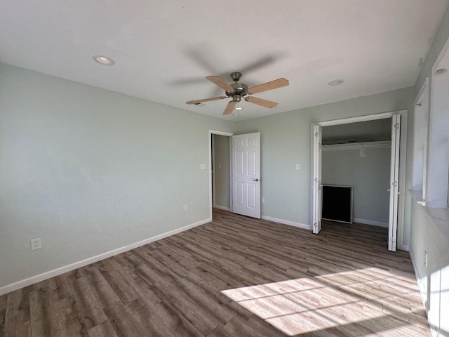 unfurnished bedroom featuring hardwood / wood-style flooring, ceiling fan, and a closet