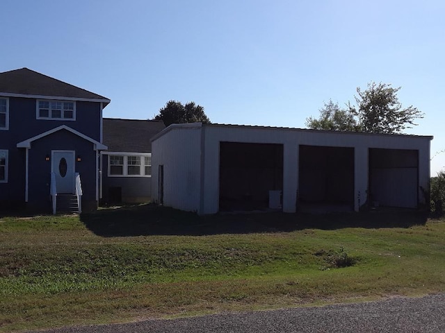 exterior space with an outbuilding, a garage, and a front lawn