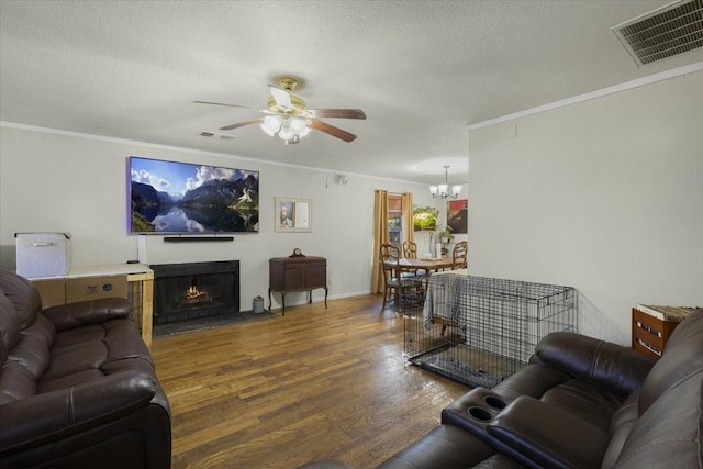 living room with a textured ceiling, crown molding, wood-type flooring, and ceiling fan with notable chandelier