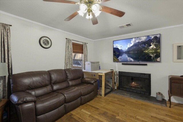 living room with ceiling fan, wood-type flooring, and crown molding