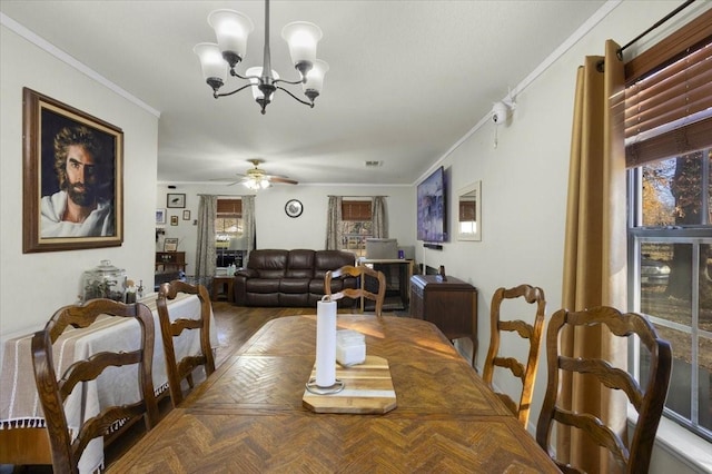 dining space featuring ceiling fan with notable chandelier and ornamental molding