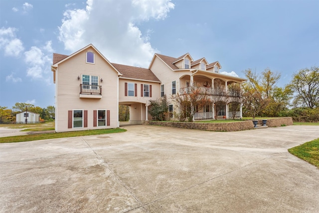 view of front of house with a balcony and concrete driveway