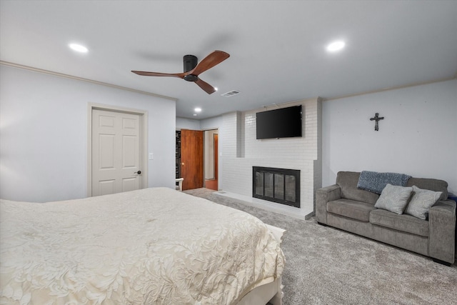 carpeted bedroom featuring a fireplace and ceiling fan