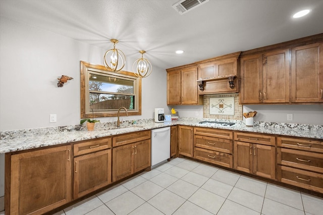 kitchen featuring a sink, brown cabinetry, white appliances, light stone countertops, and visible vents