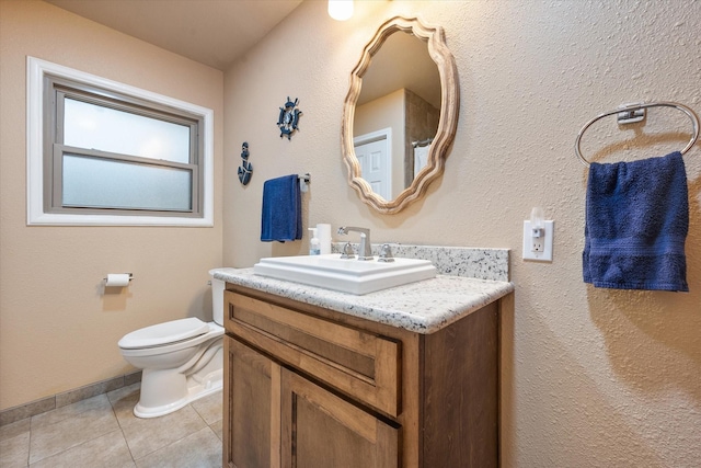 bathroom featuring tile patterned floors, baseboards, vanity, and toilet