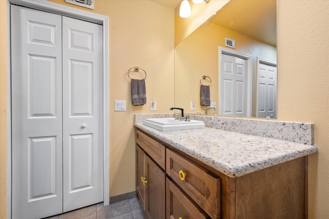 bathroom featuring a closet, tile patterned floors, vanity, and visible vents