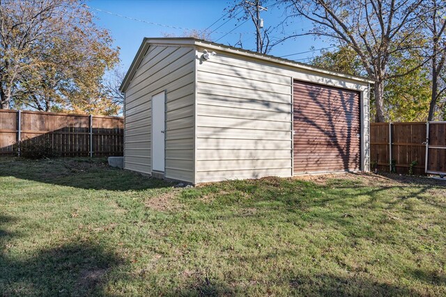view of outdoor structure featuring a fenced backyard and an outbuilding