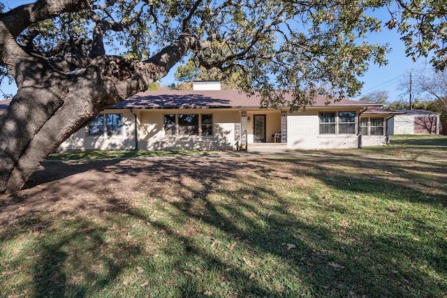 ranch-style house with brick siding and a front yard