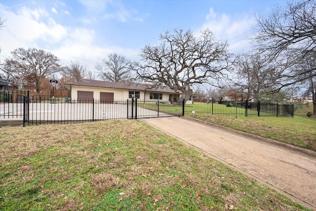 view of front facade with a fenced front yard, driveway, an attached garage, a front yard, and stucco siding
