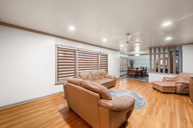 living room with ceiling fan, light wood-type flooring, and crown molding