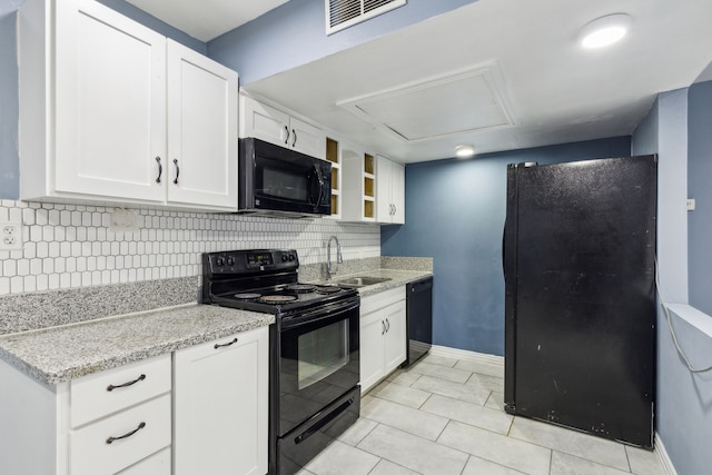 kitchen featuring backsplash, black appliances, sink, light stone countertops, and white cabinetry