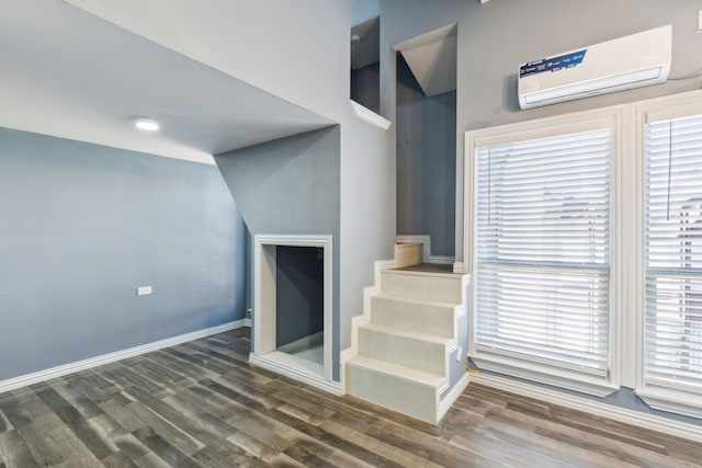 living room with a wall unit AC and dark hardwood / wood-style flooring