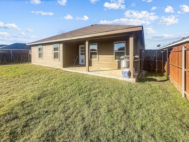 back of house with a yard and a patio area