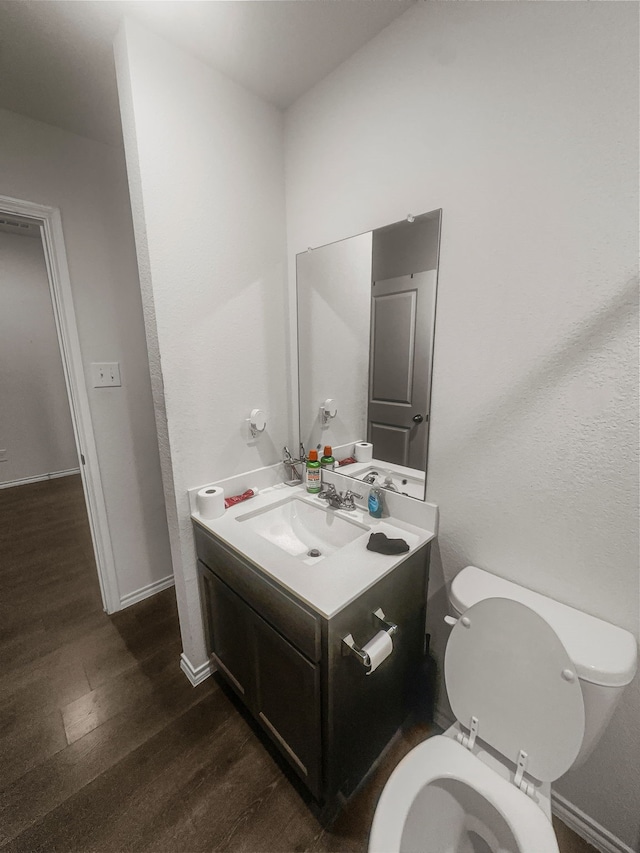 bathroom with vanity, hardwood / wood-style floors, and toilet