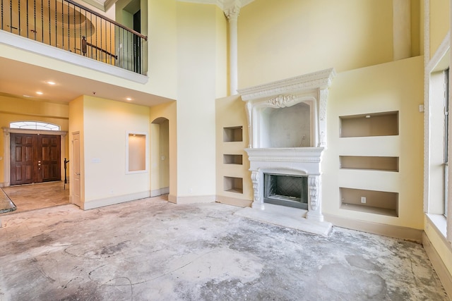 unfurnished living room with a towering ceiling