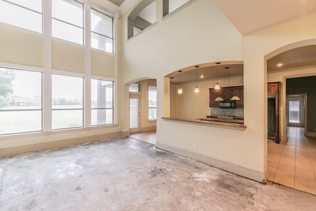 unfurnished living room with a towering ceiling