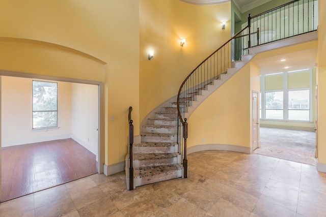 entrance foyer with a towering ceiling and light hardwood / wood-style floors