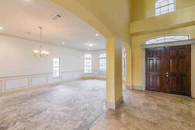 entrance foyer featuring ornamental molding and a chandelier