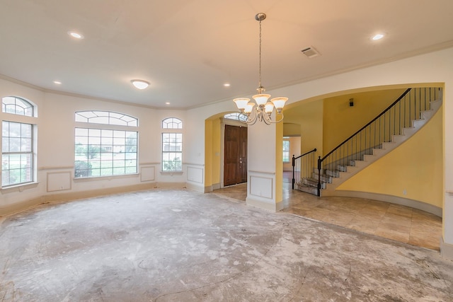 unfurnished room featuring crown molding and an inviting chandelier