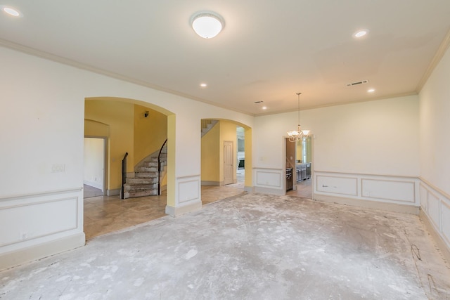 empty room featuring ornamental molding and a notable chandelier