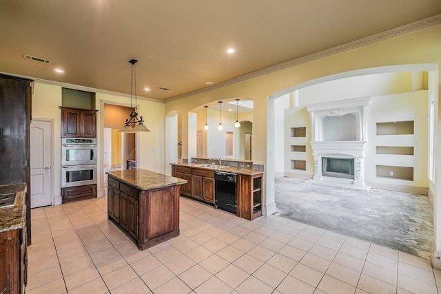 kitchen featuring stainless steel double oven, a large fireplace, crown molding, decorative light fixtures, and dishwasher