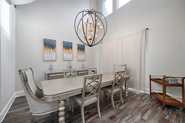 dining space with dark hardwood / wood-style floors, a chandelier, and a high ceiling