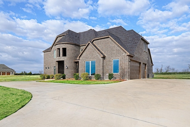 french country inspired facade with central AC unit, a garage, and a front yard