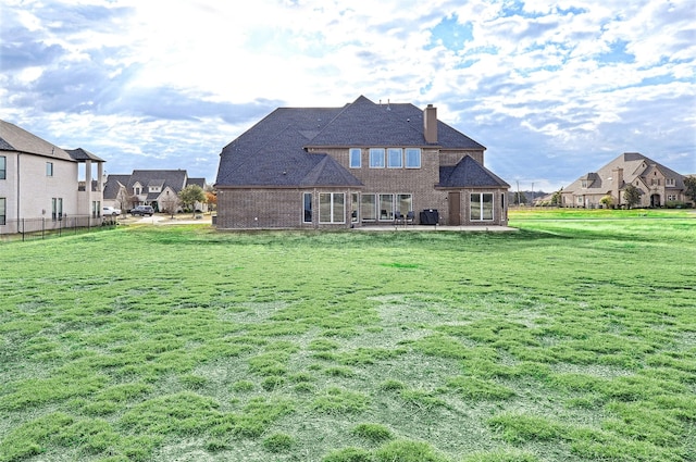 rear view of house with a yard and a patio