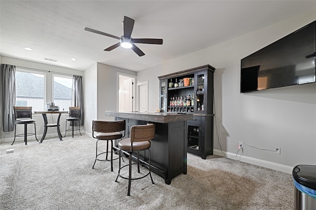 bar with ceiling fan and light carpet