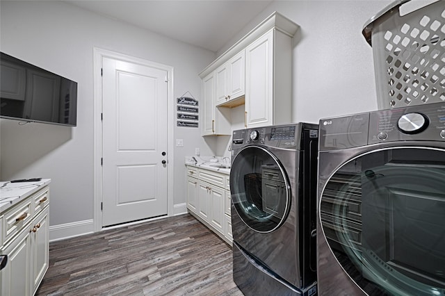 laundry area with cabinets, dark hardwood / wood-style flooring, and washer and clothes dryer