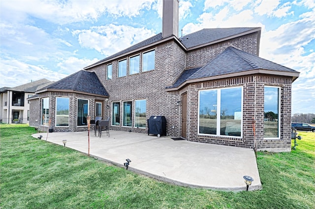 rear view of house with a yard and a patio area