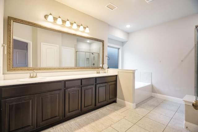 bathroom featuring plus walk in shower, vanity, and tile patterned flooring