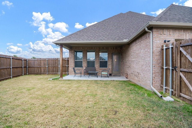 back of house with a patio area and a lawn