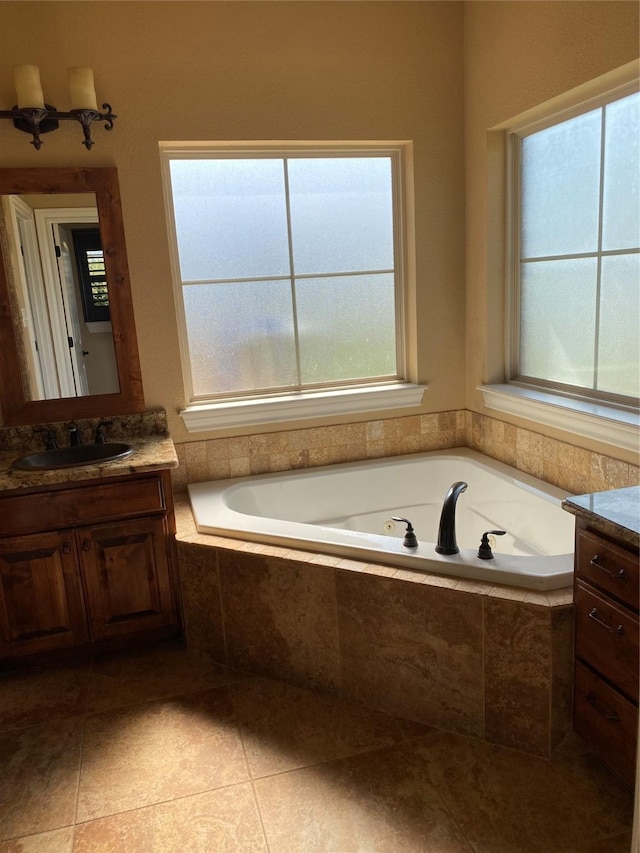 bathroom with vanity, tiled tub, and tile patterned flooring