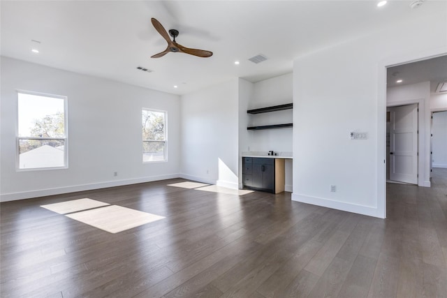 unfurnished living room featuring ceiling fan and dark hardwood / wood-style flooring