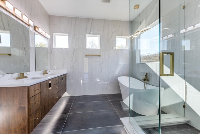 bathroom with tile walls, vanity, tile patterned floors, and separate shower and tub