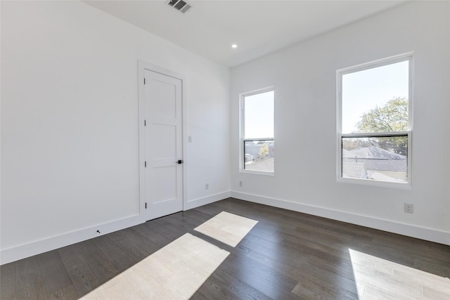 spare room featuring plenty of natural light and dark hardwood / wood-style floors