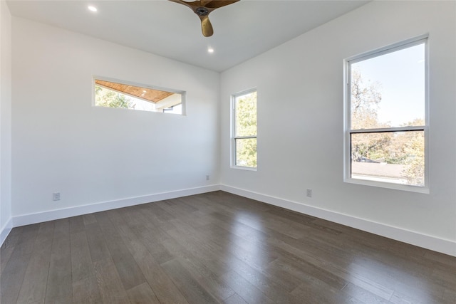 unfurnished room with a wealth of natural light, dark wood-type flooring, and ceiling fan