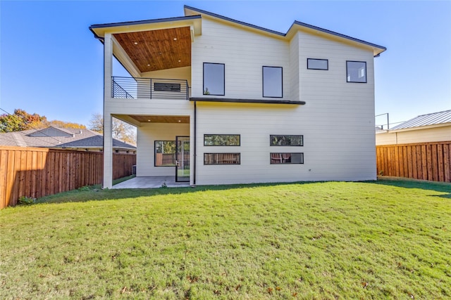 back of property featuring a lawn, a patio area, and a balcony