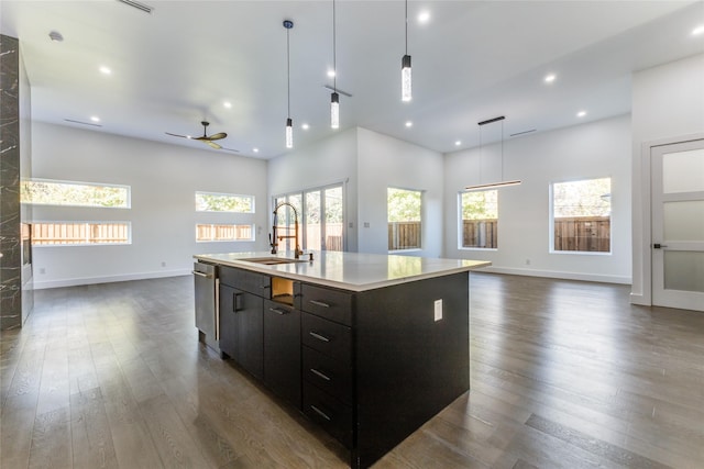 kitchen featuring dark hardwood / wood-style floors, sink, a kitchen island with sink, and hanging light fixtures