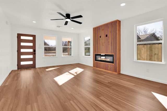 unfurnished living room featuring ceiling fan and light hardwood / wood-style flooring