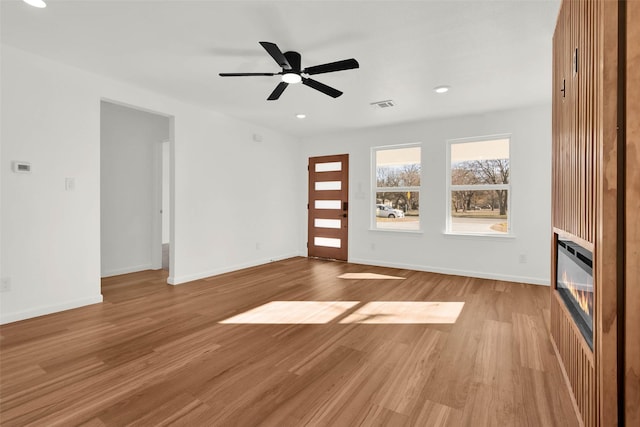 unfurnished living room featuring light hardwood / wood-style floors and ceiling fan