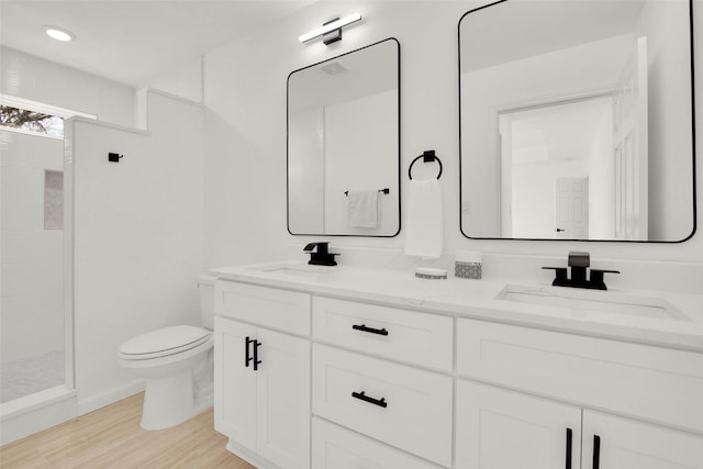 bathroom with toilet, hardwood / wood-style flooring, a shower, and vanity