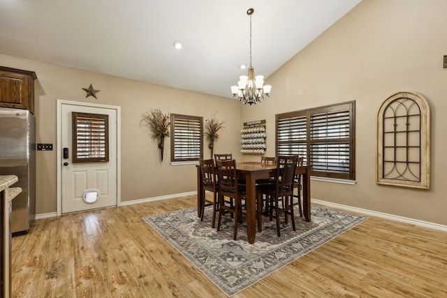 dining area featuring lofted ceiling, an inviting chandelier, and light wood-type flooring