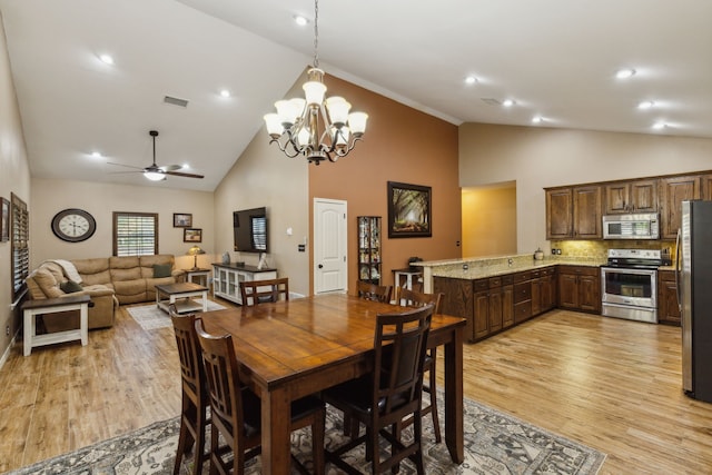 dining space with ceiling fan with notable chandelier, high vaulted ceiling, and light hardwood / wood-style flooring