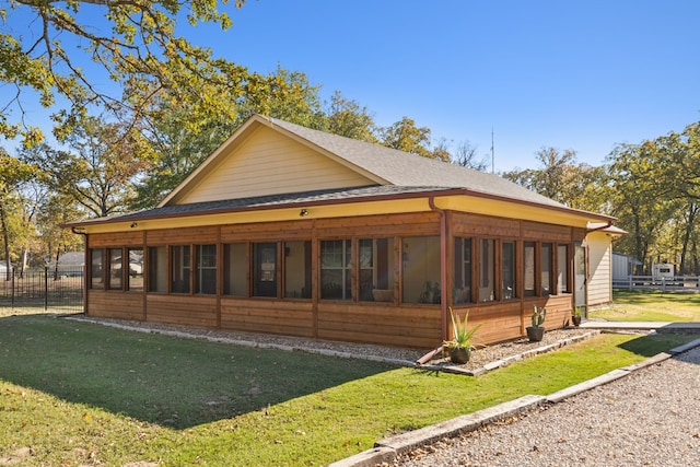 view of side of property featuring a sunroom and a yard